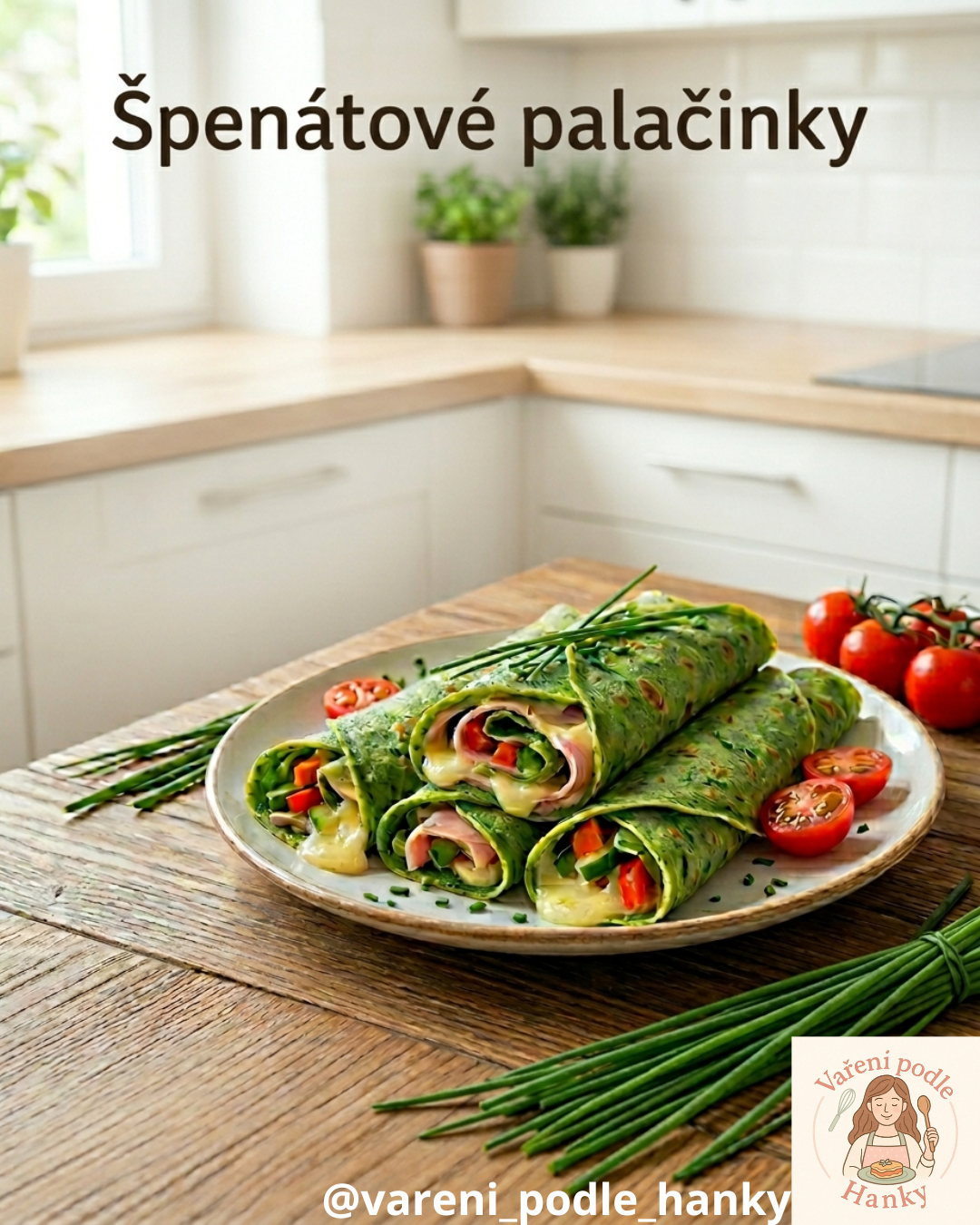 Zelené špenátové palačinky s náplní na talíři, vedle cherry rajčata a pažitka na dřevěném stole.