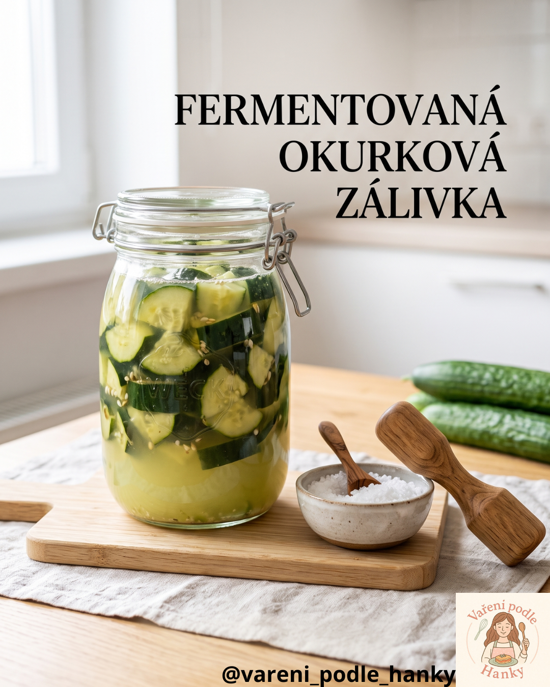 Sklenice s fermentovanými okurkami, dřevěné lžíce a miska soli na prkénku.